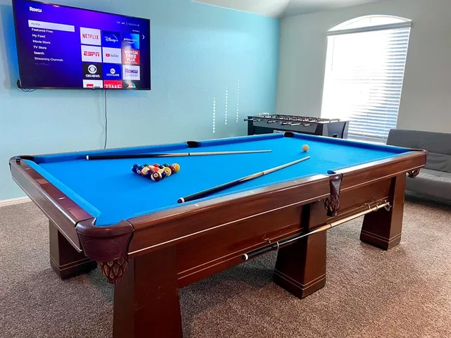 a room with pool table and windows