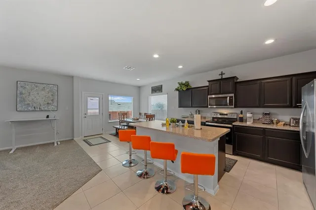 a large kitchen with a counter top space a sink a stove and cabinets
