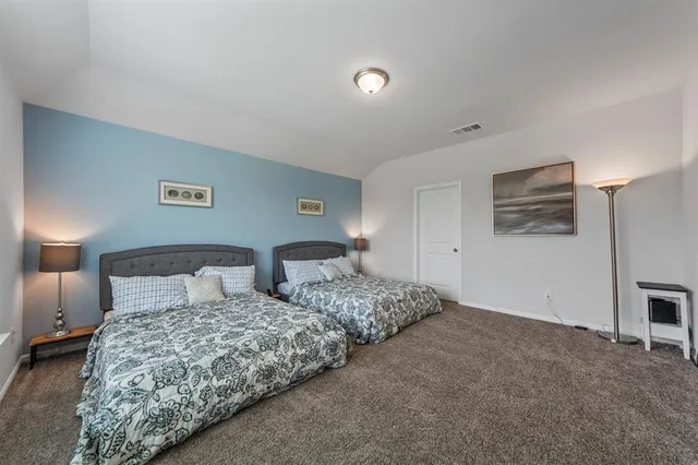 a bedroom with two beds and a lamp