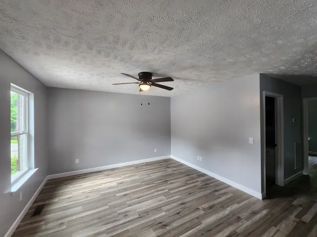 wooden floor in an empty room with a window