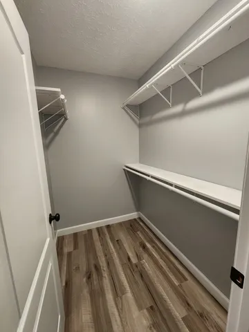 a view of closet with wooden floor
