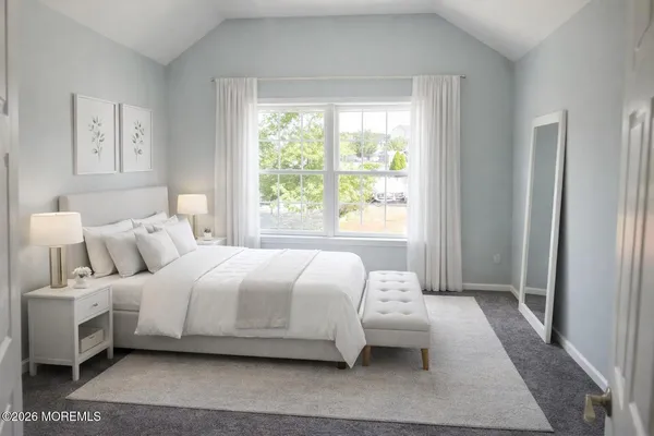 a bedroom with a bed wooden floor and window
