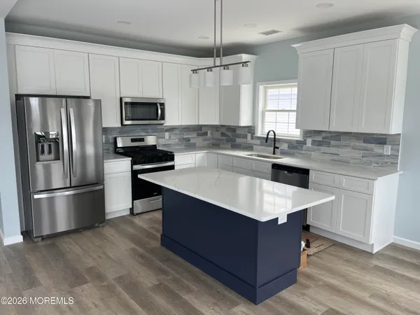 a kitchen with kitchen island a sink refrigerator and microwave