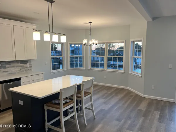 a kitchen with a dining table chairs and chandelier