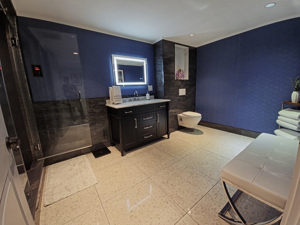 9 Venner Road Arlington, MA 02476 - Photo 13 of 40 a spacious bathroom with a granite countertop sink a toilet and mirror