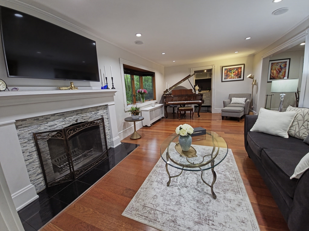 9 Venner Road Arlington, MA 02476 - Photo 2 of 40 a living room with furniture a flat screen tv and a fireplace