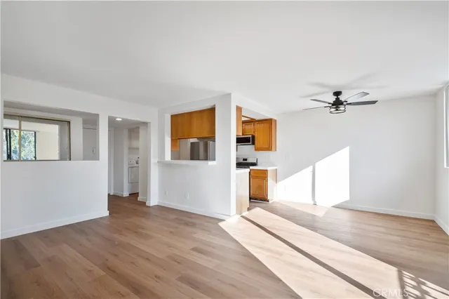 a view of a livingroom with wooden floor and a ceiling fan