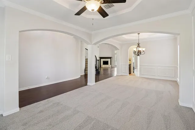 a view of a livingroom with a ceiling fan a kitchen and a chandelier fan