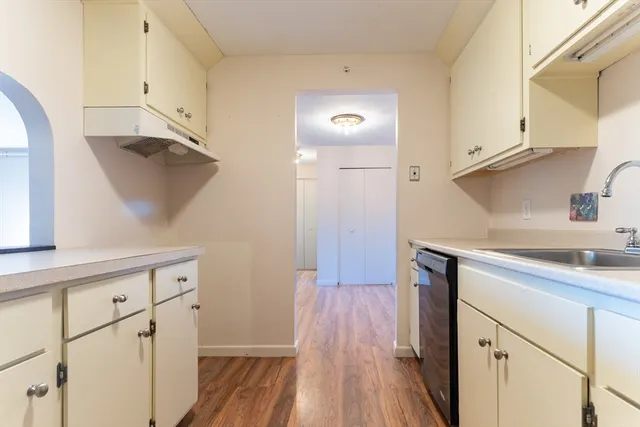 a kitchen with cabinets and wooden floor