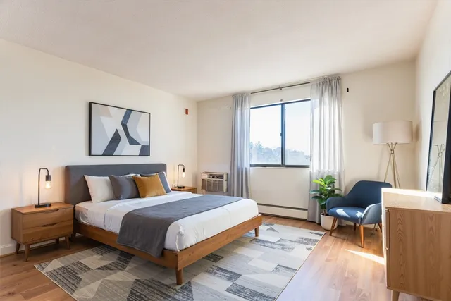 a bedroom with a bed a couch and a window