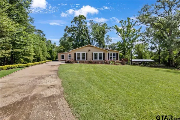 a view of an house with backyard and trees