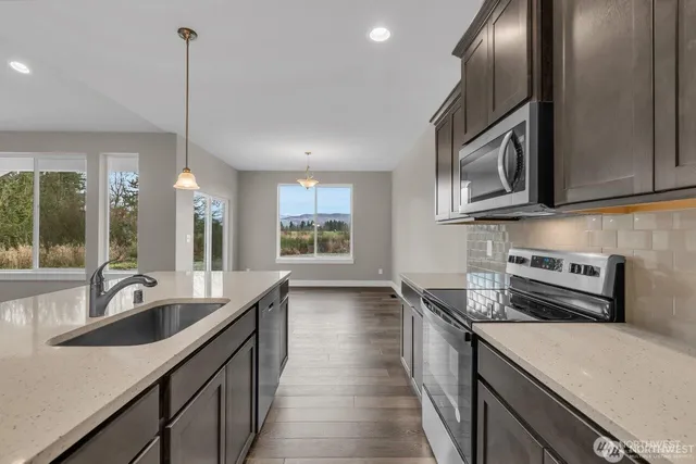 a kitchen with stainless steel appliances a sink stove and cabinets