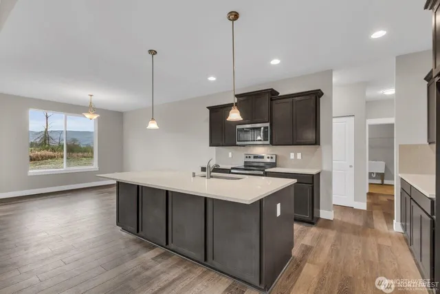 a kitchen with stainless steel appliances kitchen island a sink stove and cabinets
