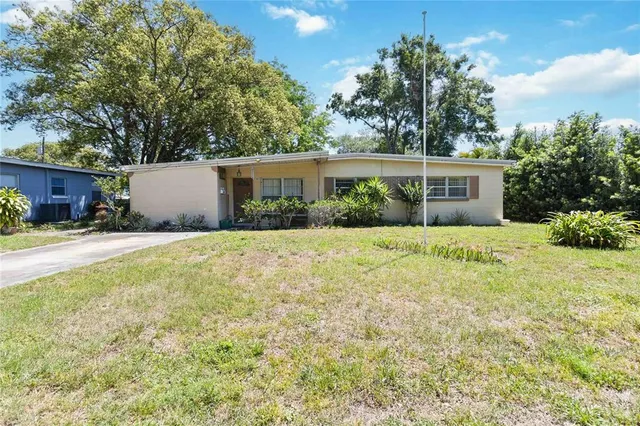 a front view of house with yard and trees around