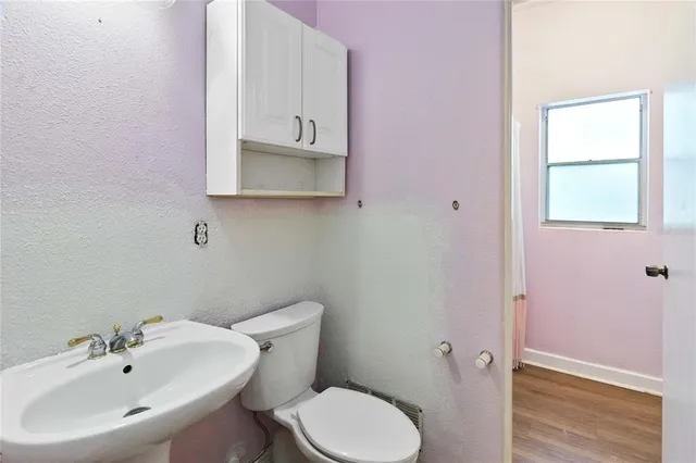 a view of a big room with wooden floor and windows