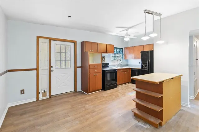 a kitchen with stainless steel appliances granite countertop a refrigerator a sink dishwasher a stove and a refrigerator with wooden floor