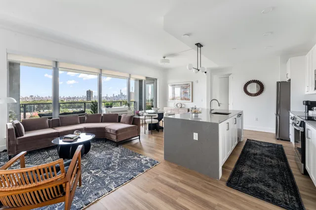a living room with furniture a window and a kitchen view