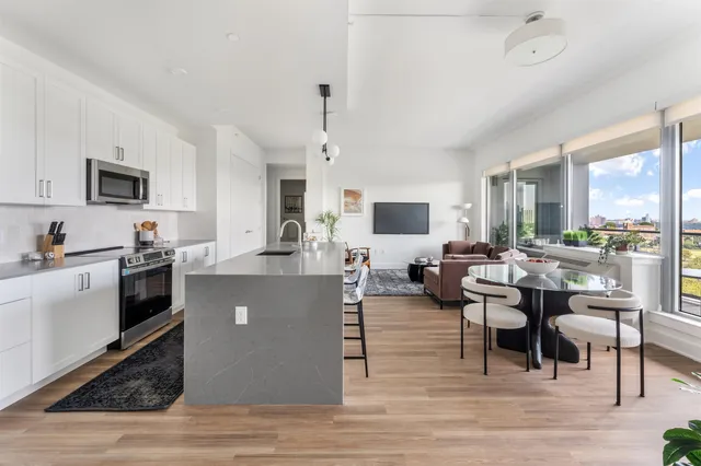 a living room with couches a flat screen tv and kitchen view