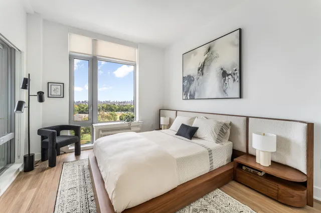 a bedroom with a bed and a large window