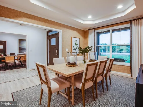 a view of a dining room and livingroom with furniture window and wooden floor