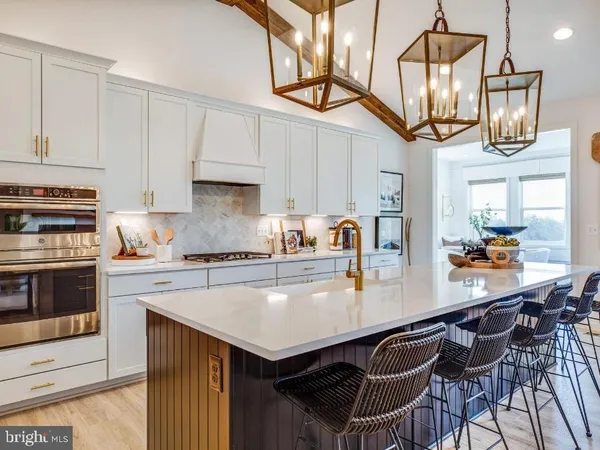 a kitchen with stainless steel appliances a table chairs and cabinets