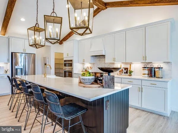 a kitchen with stainless steel appliances a table chairs and a wooden floors