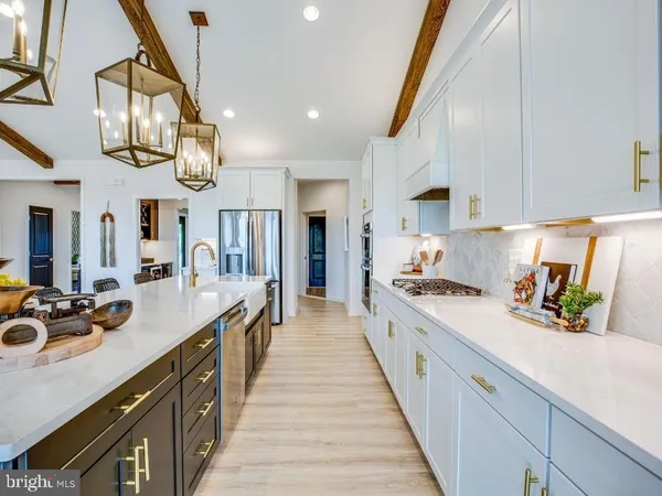 a large kitchen with stainless steel appliances lots of counter space and a sink