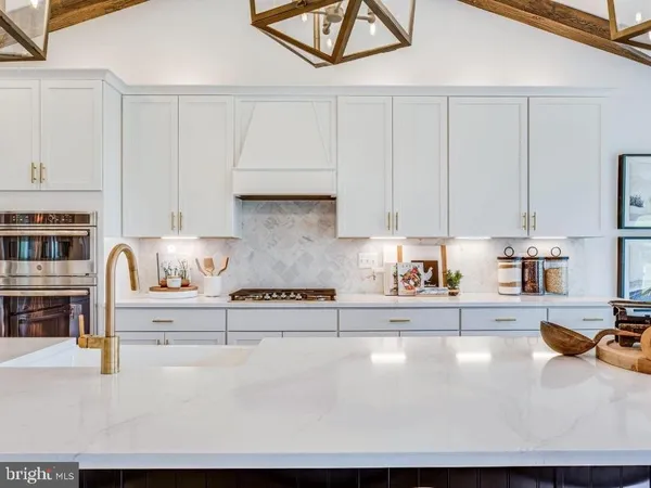 a kitchen with stainless steel appliances granite countertop a sink a stove and white cabinets