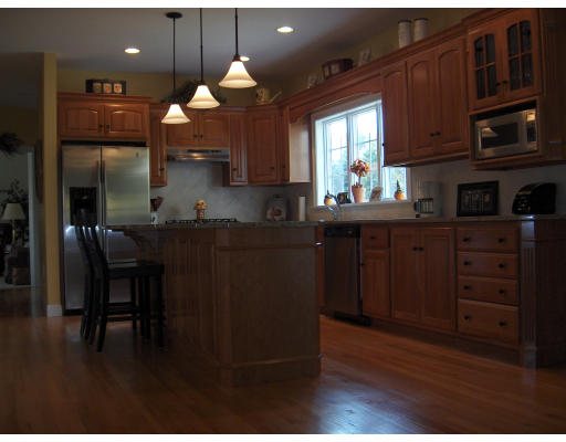 18 Symonds Way Reading, MA 01867 - Photo 3 of 26 a kitchen with granite countertop wooden floors cabinets a dining table and chairs
