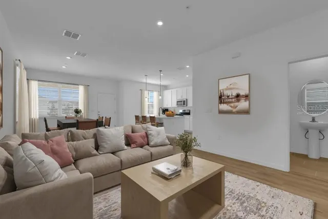 a living room with furniture and wooden floor