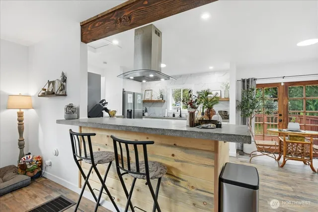 a kitchen with stainless steel appliances kitchen island granite countertop a table and chairs in it