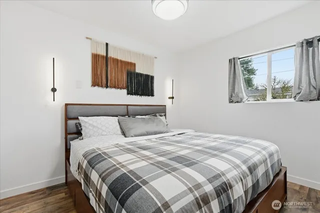 a bedroom with a large bed and a painting on the wall