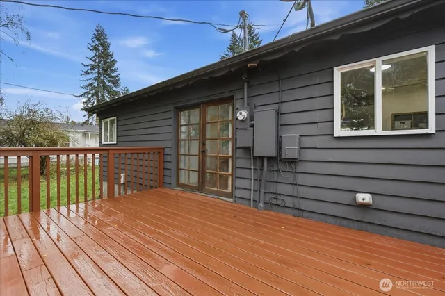 a view of backyard with wooden deck and lake view
