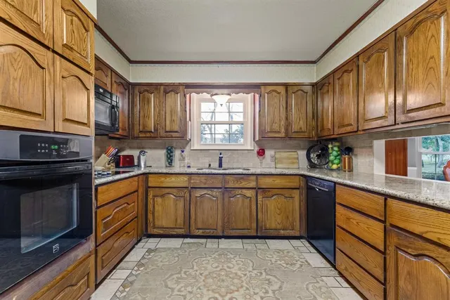 a kitchen with stainless steel appliances granite countertop a sink and cabinets