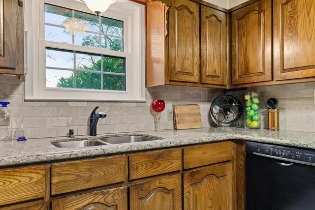 a kitchen with granite countertop stainless steel appliances a sink and a counter top