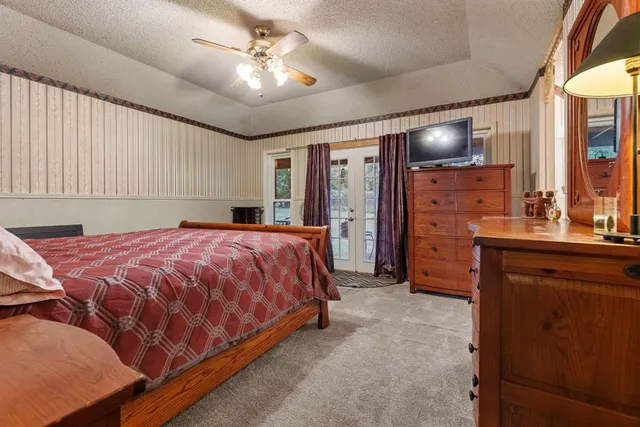 a spacious bedroom with a bed and a dresser