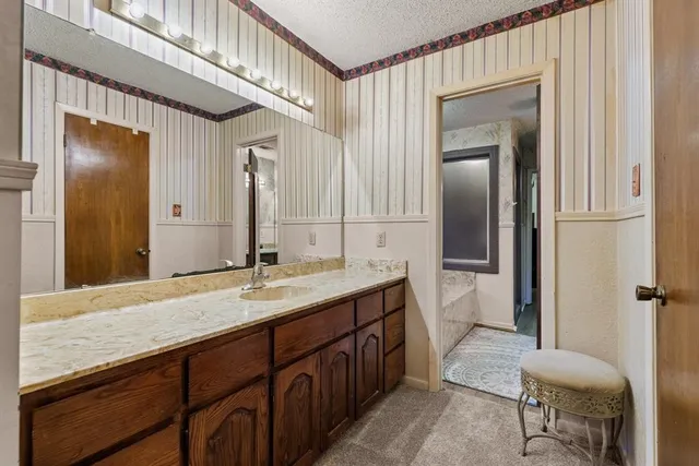 a en suite bathroom with a granite countertop sink and a mirror