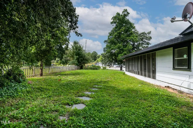 a big yard with lots of green space and trees all around