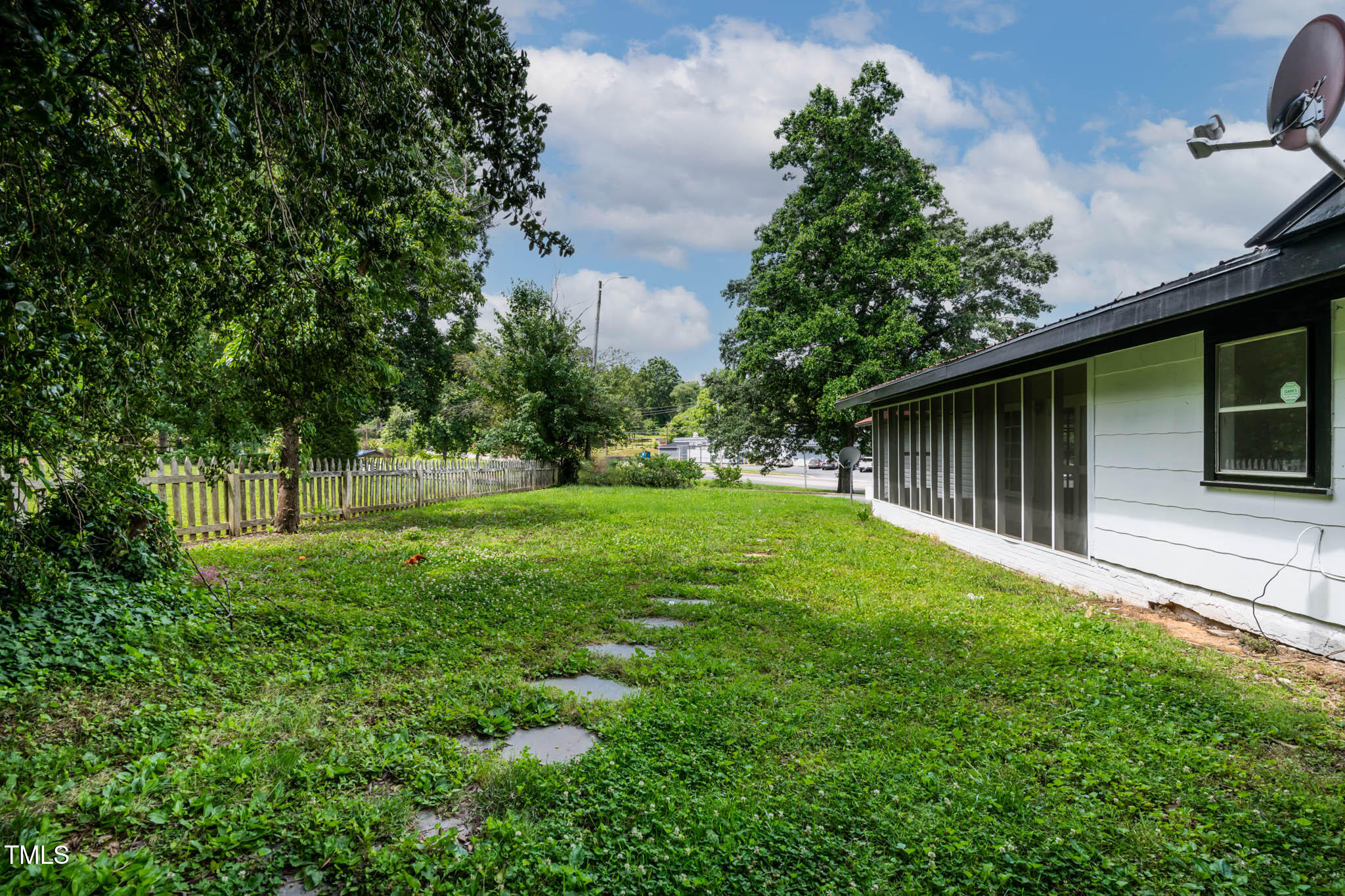 519 West Raleigh Street Siler City, NC 27344 - Photo 19 of 47 a backyard of a house with plants and large tree