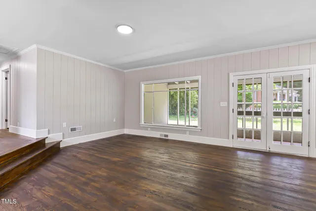 a view of empty room with wooden floor and fireplace
