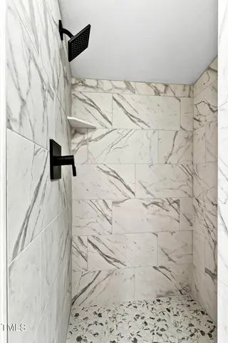 a view of an empty room with wooden floor and windows