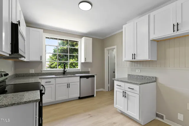 a kitchen with cabinets stainless steel appliances and a window