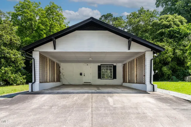 a view of a house with a yard and potted plants