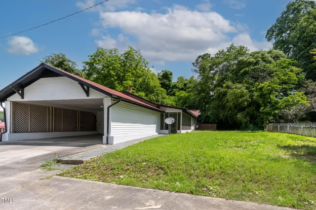 a front view of house with yard and trees in the background