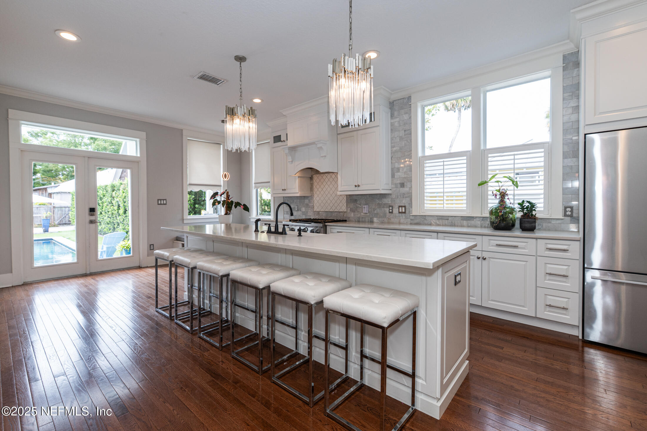56 Water Street St. Augustine, FL 32084 - Photo 26 of 61 a large white kitchen with granite countertop a stove a sink a refrigerator and a dining table with wooden floor