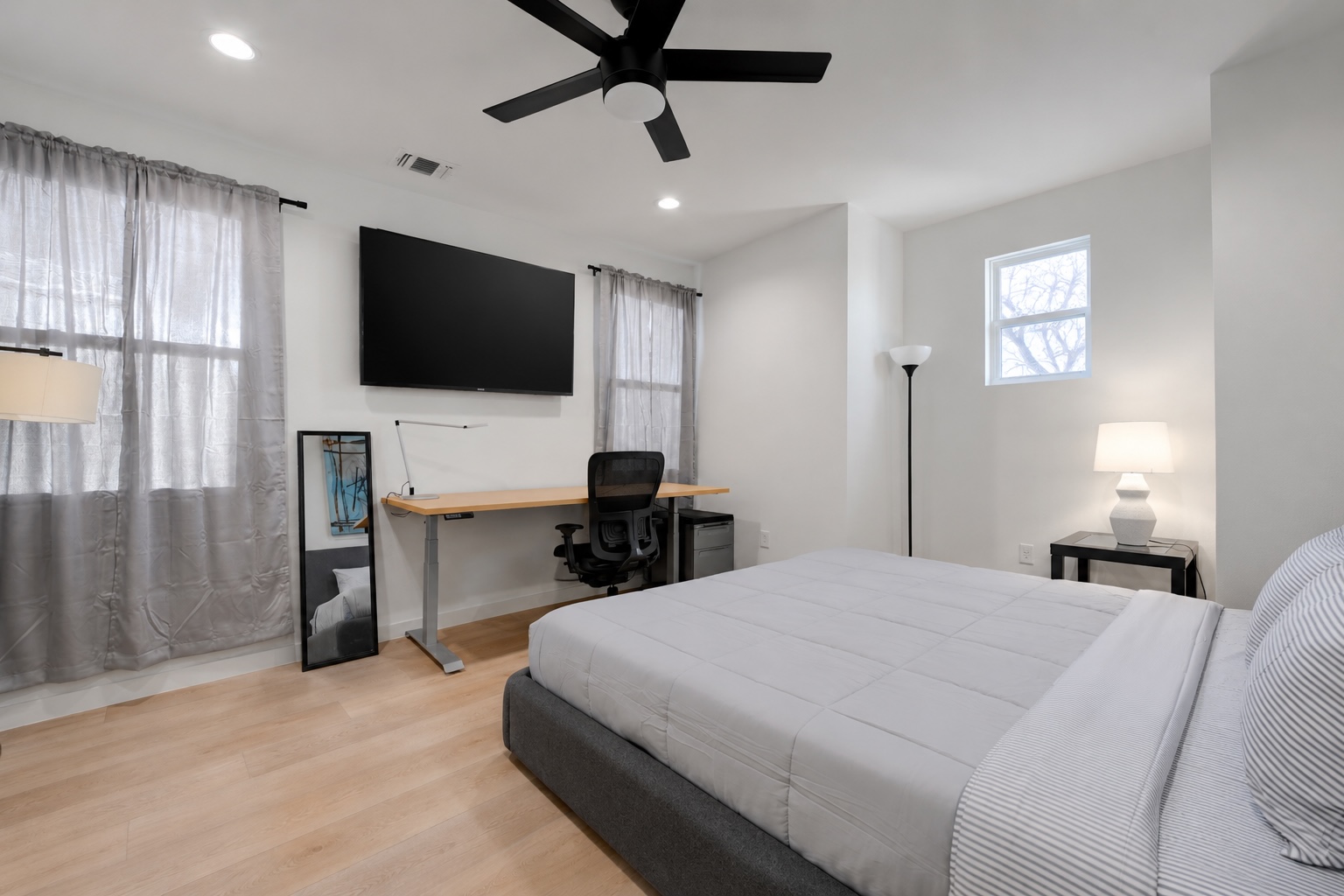 2220 Yellow Jacket Lane, Unit 1 Austin, TX 78741 - Photo 12 of 35 Well-lit sleeping quarters with a dedicated work area and a modern ceiling fan for comfort.
