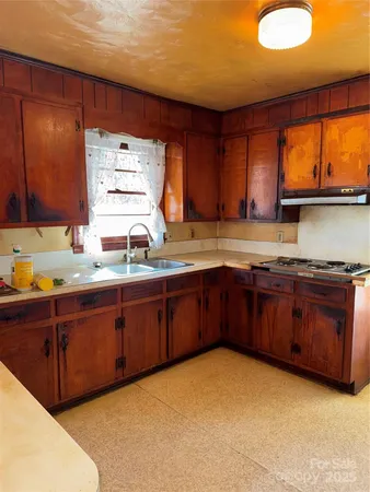 a kitchen with stainless steel appliances granite countertop wooden cabinets a sink and a stove