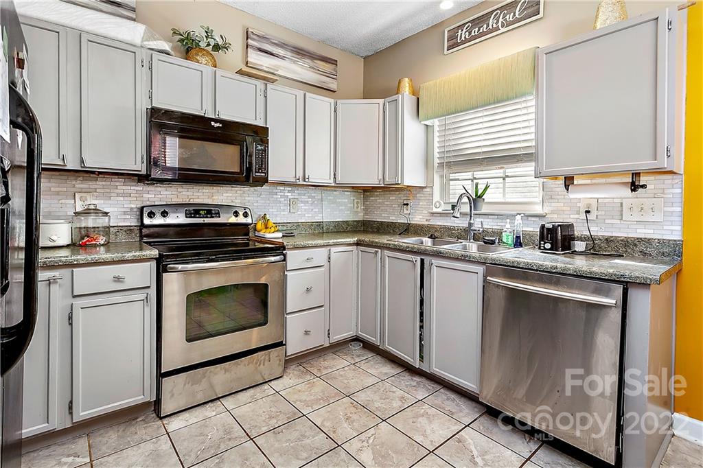 2220 Meadecroft Road Charlotte, NC 28214 - Photo 7 of 16 a kitchen with white cabinets stainless steel appliances and sink