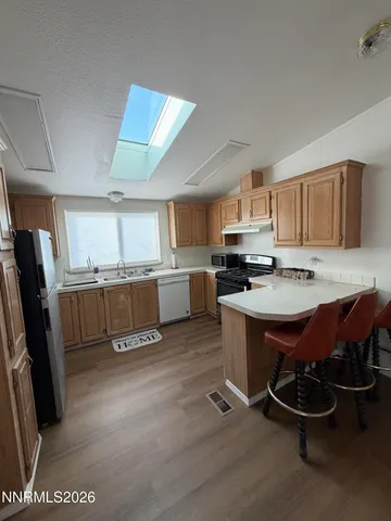 a open kitchen with stainless steel appliances granite countertop a refrigerator dining table and chairs