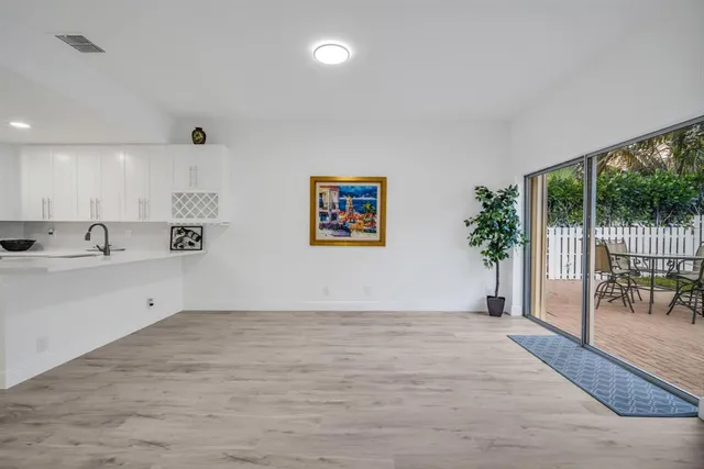 a living room with furniture and kitchen view with wooden floor